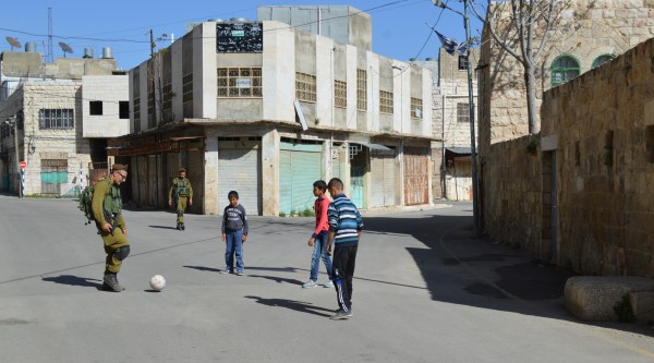 En något annorlunda men hoppingivande syn med israeliska soldater som spelar fotboll med palestinska grannpojkar.