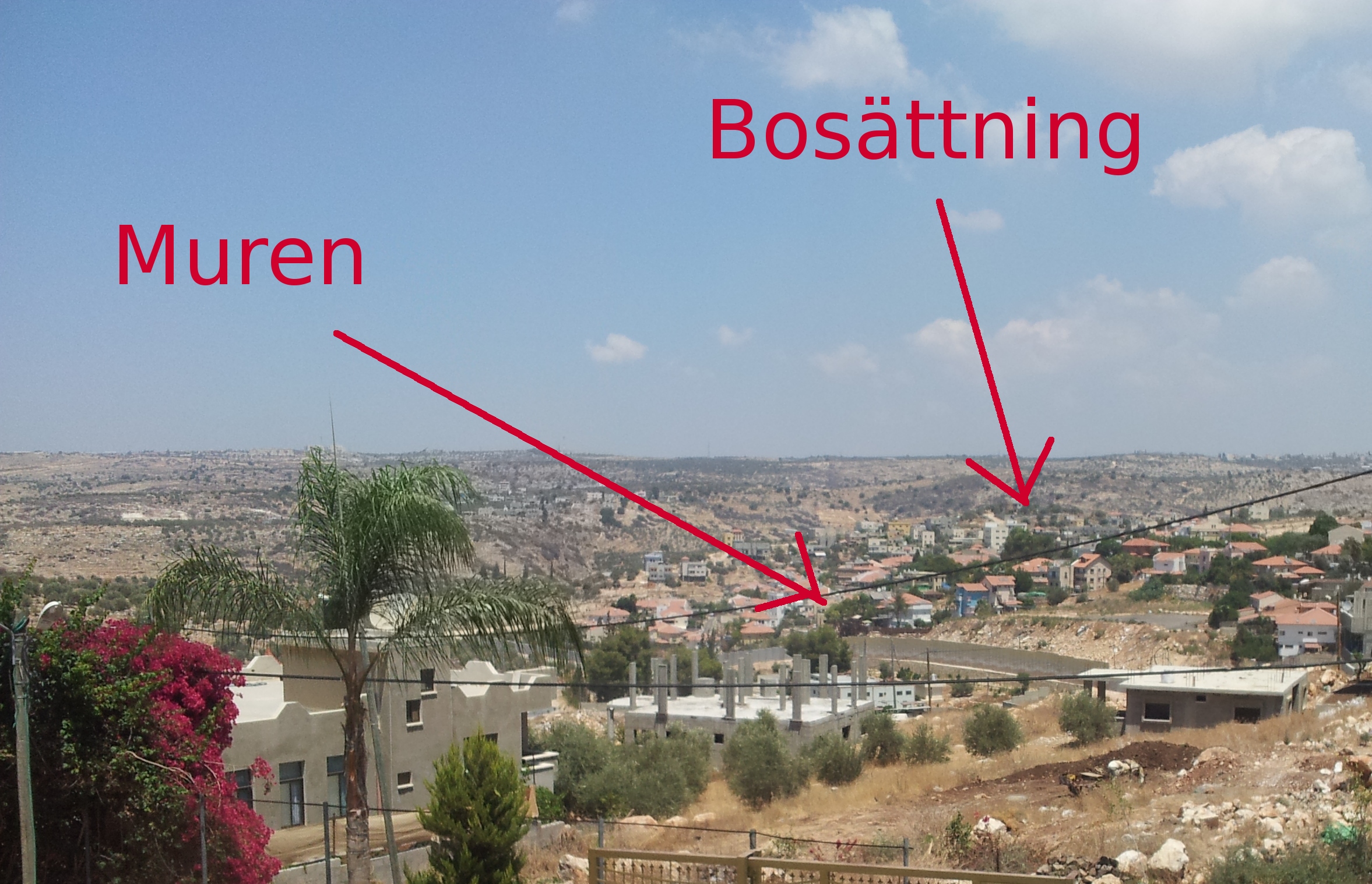 Bild från Azzun Attma över byn med vy över muren och närmaste bosättning.