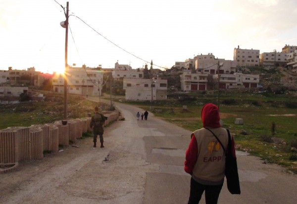 Israeliska bosättare, israelisk soldat och följeslagare på Prayer’s Road. Foto: Eric Röst