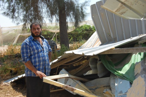 Tvåbarnspappan Yakoub, 24 år, framför det rivna huset. Bakom honom skymtar en vindruvsodling som tillhör en bosättning. 