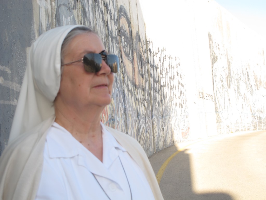 Syster Lucia Gemma i kvällssol intill muren.