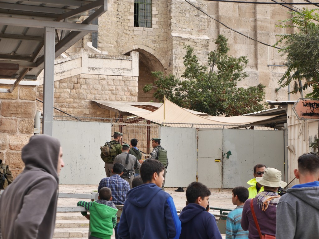 Ung palestinsk man förs bort av soldater vid ingången till Ibrahimimoskén.