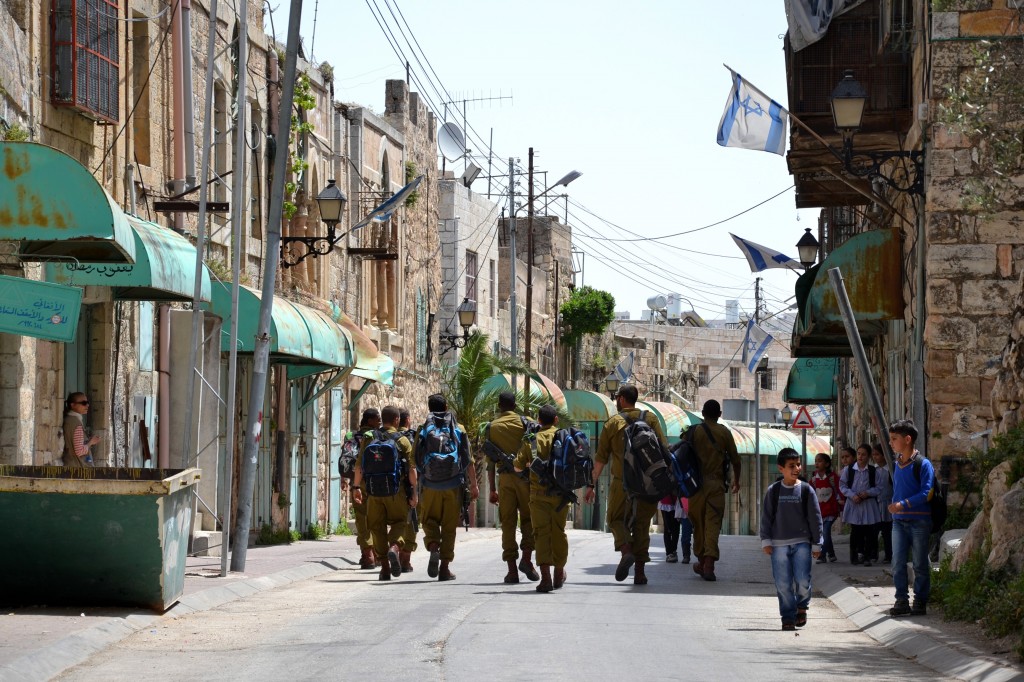 Skolbarn möter israelisk militär på Shuhada Street i Hebron