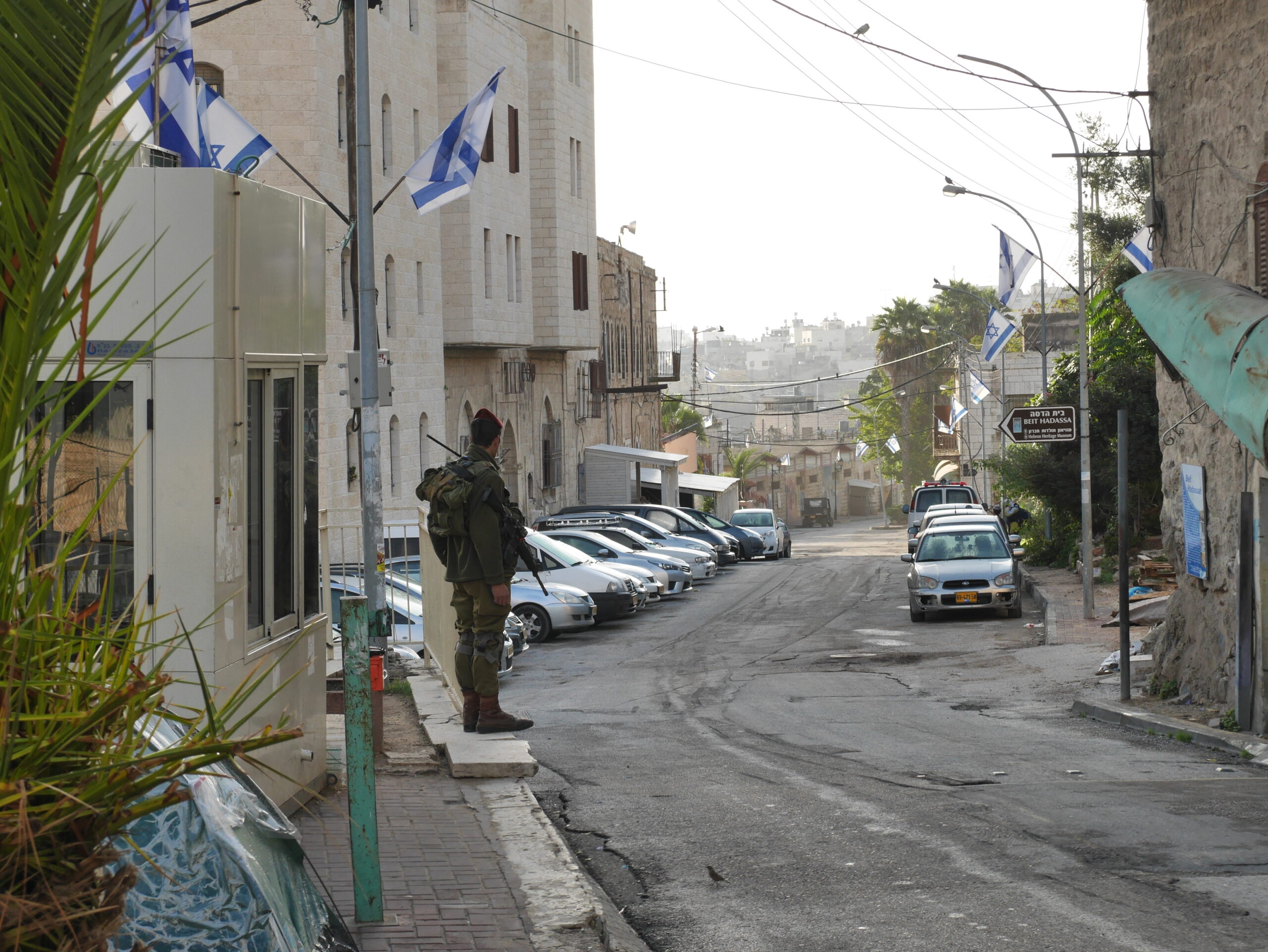 Soldat som vaktar vägspärr 55. Till vänster syns hans vaktkur. Rakt fram delen av Shuhadagatan som palestinier inte får gå på.