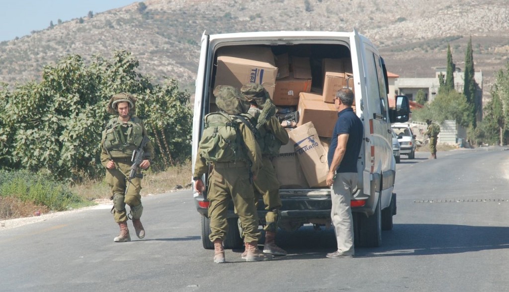 En tillfällig vägspärr utanför den palestinska byn Burin. Israelisk militär stoppar och kontrollerar oannonserat passerande palestinska fordon.